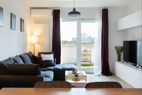 a living room with a couch and a tv at Stylish 2BDR Apartment- Free Garage in Zagreb