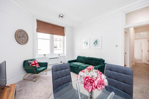a living room with a green couch and a table at Leicester Square Apartment in London