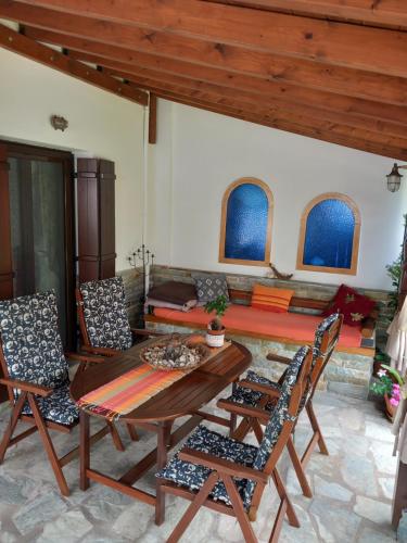 a living room with a wooden table and chairs at Poly's Sea Side House in Koropi