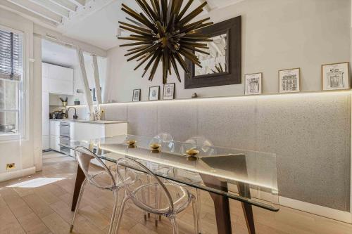 une salle à manger avec une table et des chaises en verre dans l'établissement Bleu Nuit, à Paris