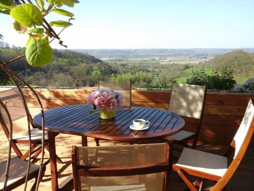 - une table et des chaises sur une terrasse avec vue dans l'établissement Les Terrasses De Bessou, à Clermont-Dessous