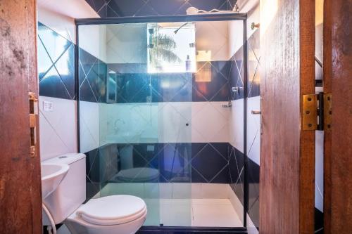 a bathroom with a toilet and a glass shower at Apto a 300 metro da praia - WIFI 200MB - Cozinha equipada - Ar condicionado in Rio das Ostras