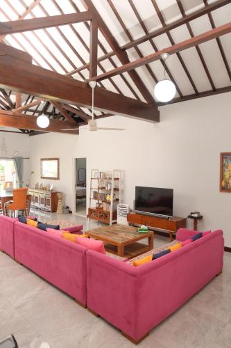 een woonkamer met een grote bank en een televisie bij Shoreside Semat Villa and Flat in Jepara