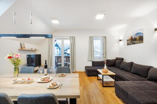 un soggiorno con divano e tavolo di Chic Apartments with Finnish Sauna and Jacuzzi a Kranjska Gora