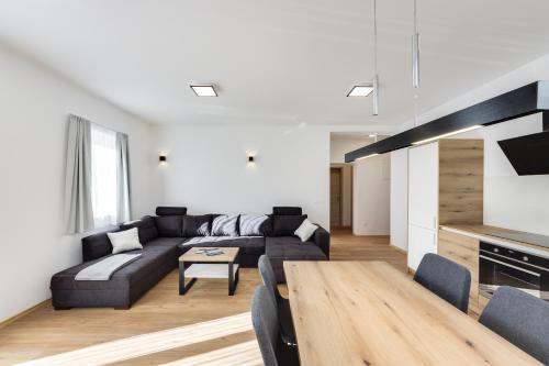 a living room with a couch and a table at Chic Apartments with Finnish Sauna and Jacuzzi in Kranjska Gora