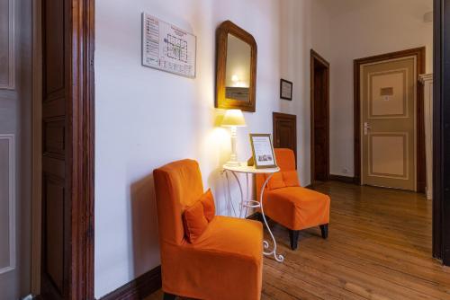 a room with two chairs and a table and a mirror at Hôtel & Espace Bien-être La Maison du Lierre in Biarritz