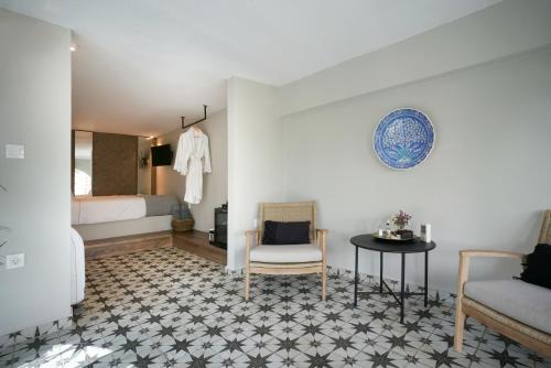 a bedroom with a bed and a table and a chair at Pafsilipon Suites in Ermoupoli