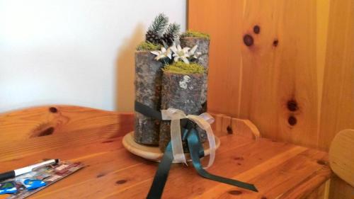a vase with plants in it on a wooden table at Hotel Adele in Livigno