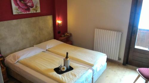 a bedroom with a bed with a bottle of wine at Hotel Adele in Livigno