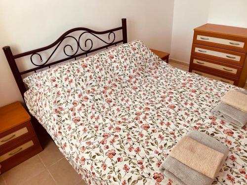 a bed with a floral comforter on it in a bedroom at Rent 1 bed in amazing complex CC in Didim