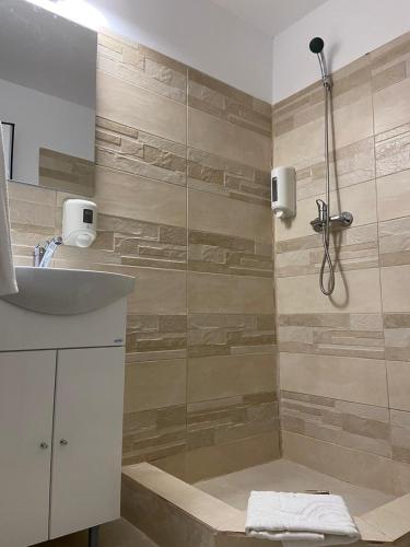 ein Badezimmer mit Dusche und Waschbecken in der Unterkunft ADMAR Rooms & Restaurant in Costinești