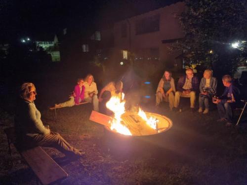a group of people sitting around a fire pit at night at Burgenwelt im wilden Süden in Münsingen