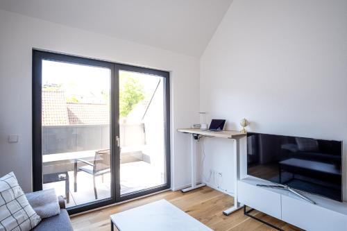 a living room with a large window and a tv at KEEP Business Suite H66-2 nahe Audi & Schwarz Gruppe mit Balkon, Netflix & Parkplatz in Oedheim