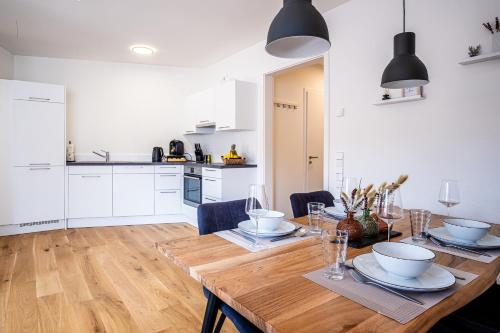 a kitchen and dining room with a wooden table at KEEP Business Suite H66-2 nahe Audi & Schwarz Gruppe mit Balkon, Netflix & Parkplatz in Oedheim
