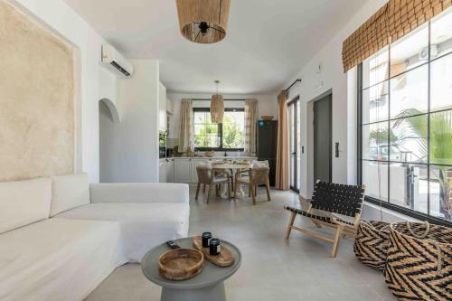 a living room with a white couch and a table at Nikole cottage house by the sea in Kokkini Khanion