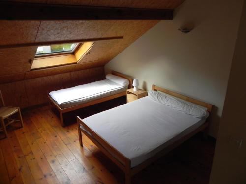 ein kleines Schlafzimmer mit 2 Betten und einem Fenster in der Unterkunft Camping Le Castella in Luzenac