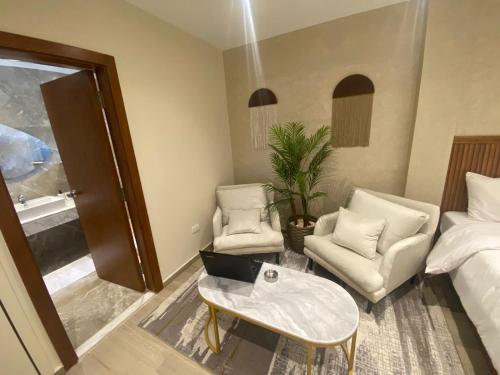 Nakhil Inn Residence في القاهرة: غرفة معيشة مع سرير وأريكة وطاولة