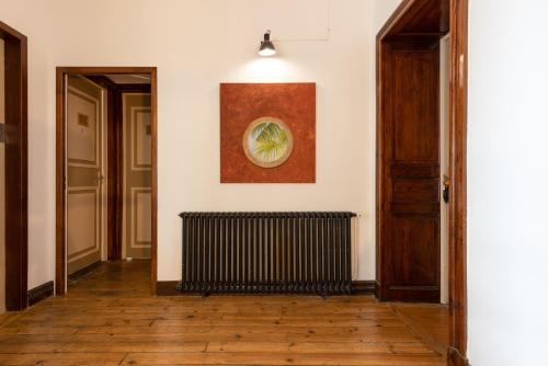 a hallway with a radiator and a painting on the wall at Hôtel & Espace Bien-être La Maison du Lierre in Biarritz