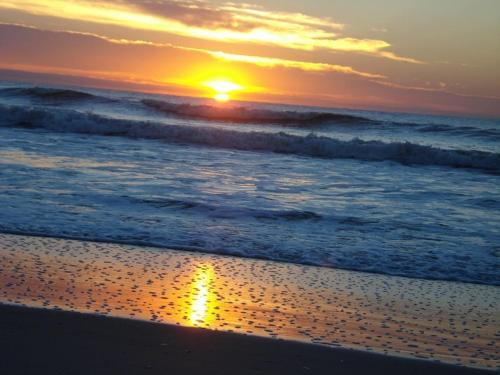 a sunset on a beach with the ocean at Pousada Margareth in Ilha do Mel