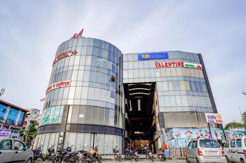 un gran edificio de cristal con motocicletas estacionadas frente a él en FabHotel The Valentine, en Surat