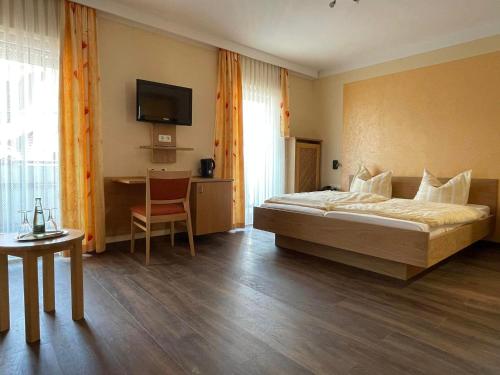尼希施泰因的住宿－孔尼斯坦納霍夫酒店，一间卧室配有一张床、一张书桌和一台电视。