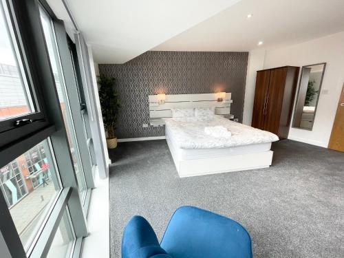 a bedroom with a bed and a blue chair at The Works-Fresh 2bed in centre, opposite Arndale. in Manchester