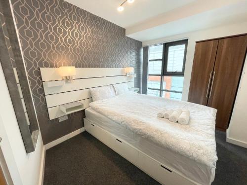 a bedroom with a bed with two towels on it at The Works-Fresh 2bed in centre, opposite Arndale. in Manchester