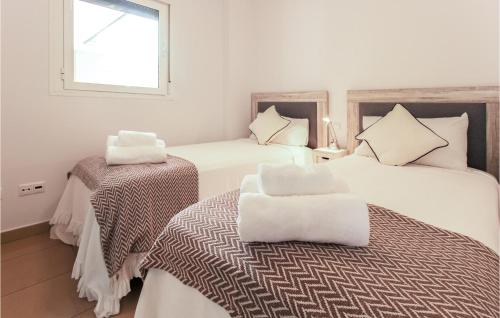 プラヤ・フラメンカにあるBeautiful Apartment In Orihuela With 2 Bedrooms, Wifi And Outdoor Swimming Poolのベッド2台と窓が備わるホテルルームです。
