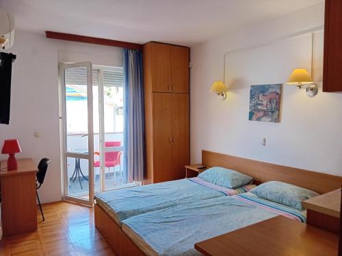 Schlafzimmer mit einem Bett und einer Tür zu einem Balkon in der Unterkunft Vila Centar in Trebinje