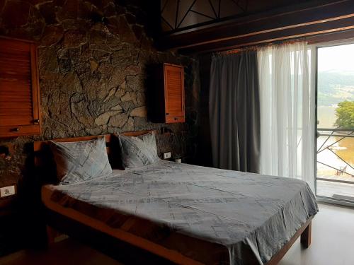 a bedroom with a bed with a large window at La Piticu in Dubova