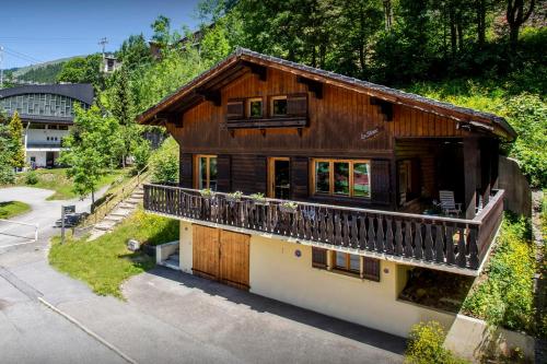 a large wooden house with a balcony at Chalet Bellanis - OVO Network in Morzine