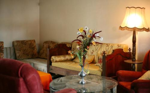 un salon avec une table avec un vase de fleurs dans l'établissement Eco-Gîte du Moulin de Dun, Ariège, à Dun