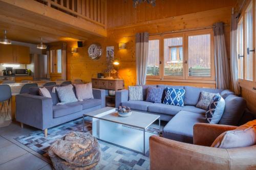 un salon avec des canapés bleus et une table dans l'établissement Chalet Bellanis - OVO Network, à Morzine