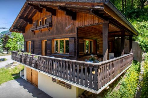 a log house with a porch and a balcony at Chalet Bellanis - OVO Network in Morzine