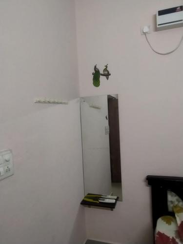 uma parede branca com um espelho num quarto em P. G. REDDY HOME STAY em Tirupati