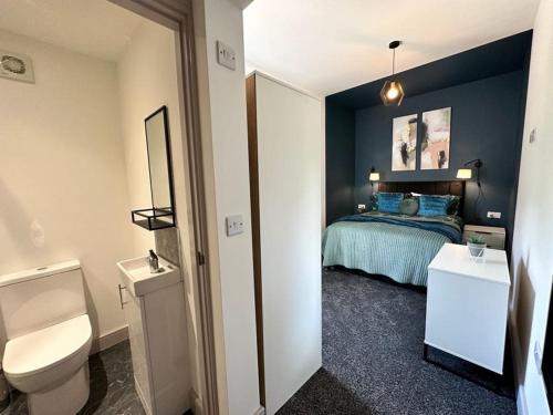 a bathroom with a bedroom with a bed and a toilet at Sophisticated Silcoates in Wakefield
