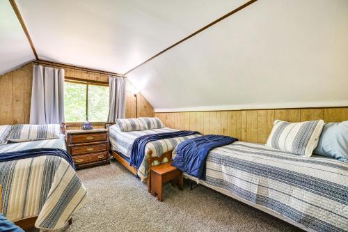 1 dormitorio con 2 camas y ventana en Family Roscommon Home - 3 Mi to Higgins Lake en Roscommon