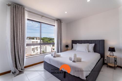a bedroom with a bed and a large window at #169 T3 Medronheira by Home Holidays in Olhos de Água