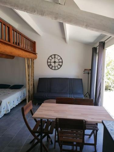 une pièce avec une table, des chaises et un canapé dans l'établissement Meublé chaleureux en Provence, à Cheval-Blanc