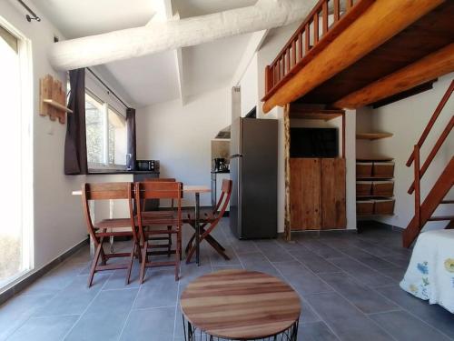 a kitchen with a table and chairs and a refrigerator at Meublé chaleureux en Provence in Cheval-Blanc