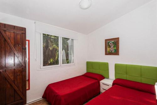 a bedroom with two beds and a window at Villa Palmera in Cala'n Porter