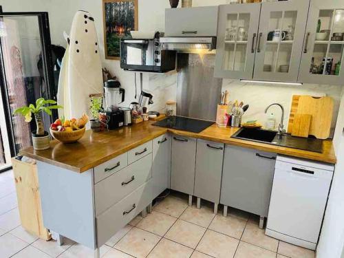 une cuisine avec des armoires blanches et un comptoir en bois dans l'établissement Cosy Villa Patio, à Seignosse