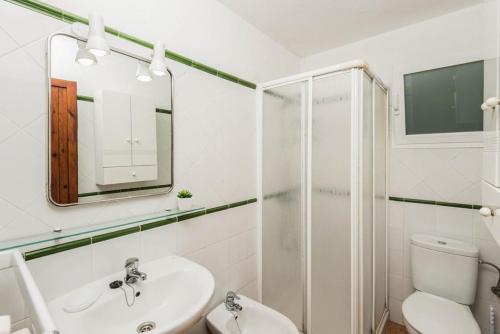 a white bathroom with a sink and a shower at Villa Palmera in Cala'n Porter