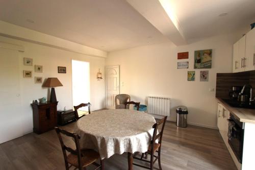 a dining room with a table and chairs and a kitchen at Joli appartement avec balcon au coeur de Forcalquier in Forcalquier