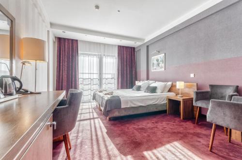 um quarto de hotel com uma cama, uma mesa e cadeiras em Hotel Swing na Cracóvia