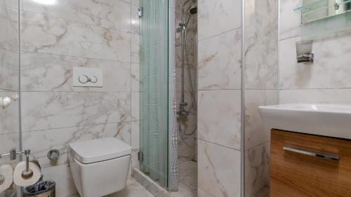 a bathroom with a shower and a toilet and a sink at Bertiz Mignon in Bozcaada