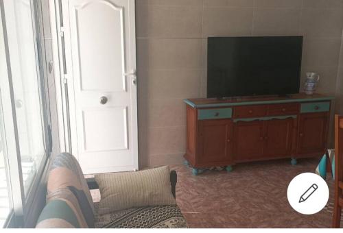 een woonkamer met een bank en een flatscreen-tv bij La casa del pescador in Santa Pola