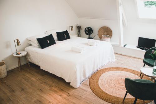 een slaapkamer met een groot wit bed met zwarte kussens bij B&B in woonboerderij vlakbij Lemmer in Rutten