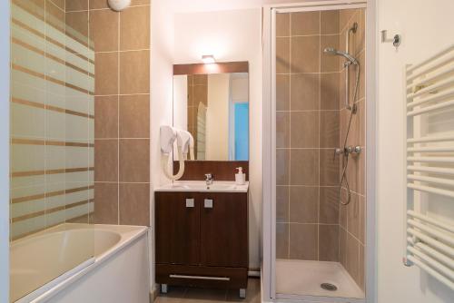 een badkamer met een bad, een wastafel en een douche bij Le Kichen - Appt proche de la plage in Bénodet