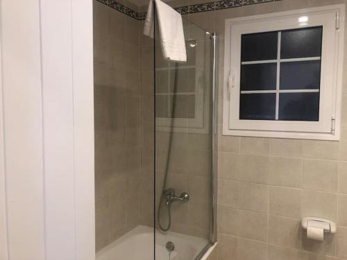 a shower with a glass door and a window at Relax Playa Son Bou, Menorca in Son Bou